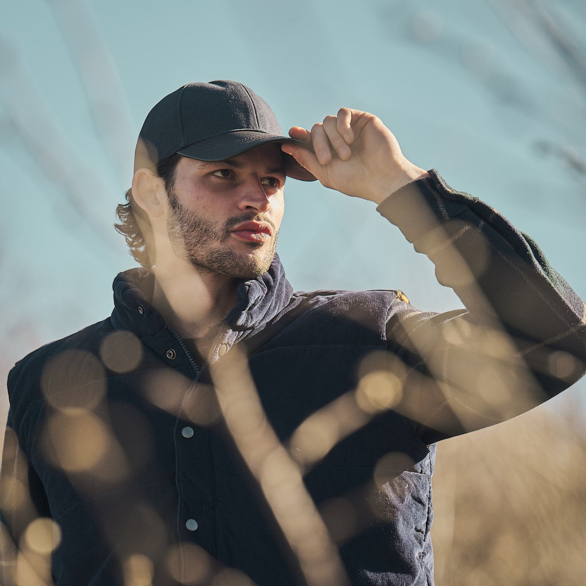 Mann mit dunkler Baseballkappe in einer Berglandschaft – Inspiration für Lennox