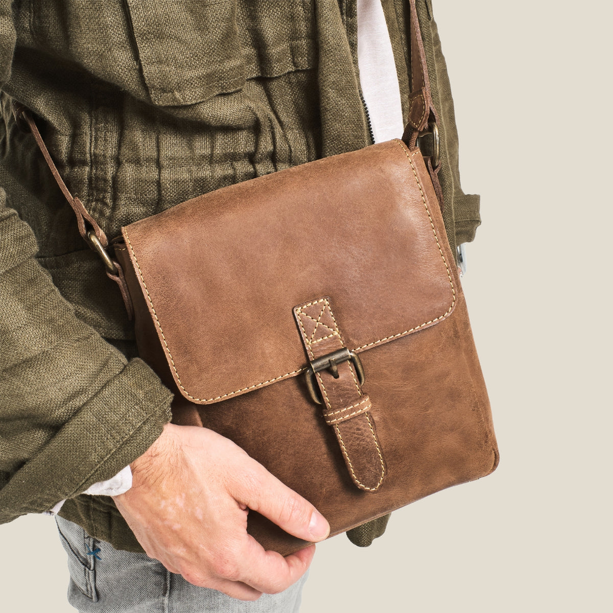 Mann mit Carl in Havanna-Braun als kompakter Crossbody Bag im Alltag