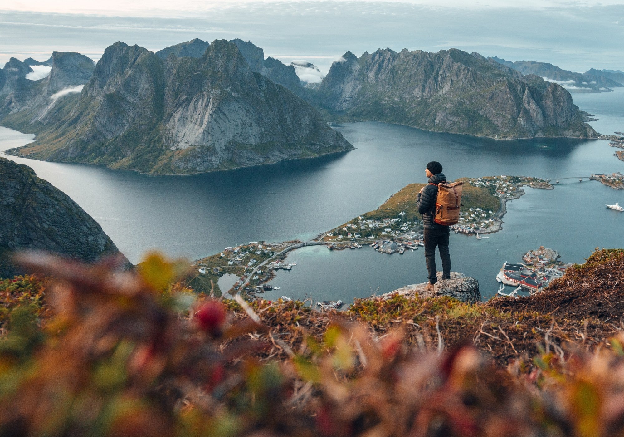 Mann steht an den Lofoten in Norwegen und schaut sich das unglaubliche Panorama an - Ein hat einen großen Wachs Canvas Rucksack von DRAKENSBERG dabei -3-4