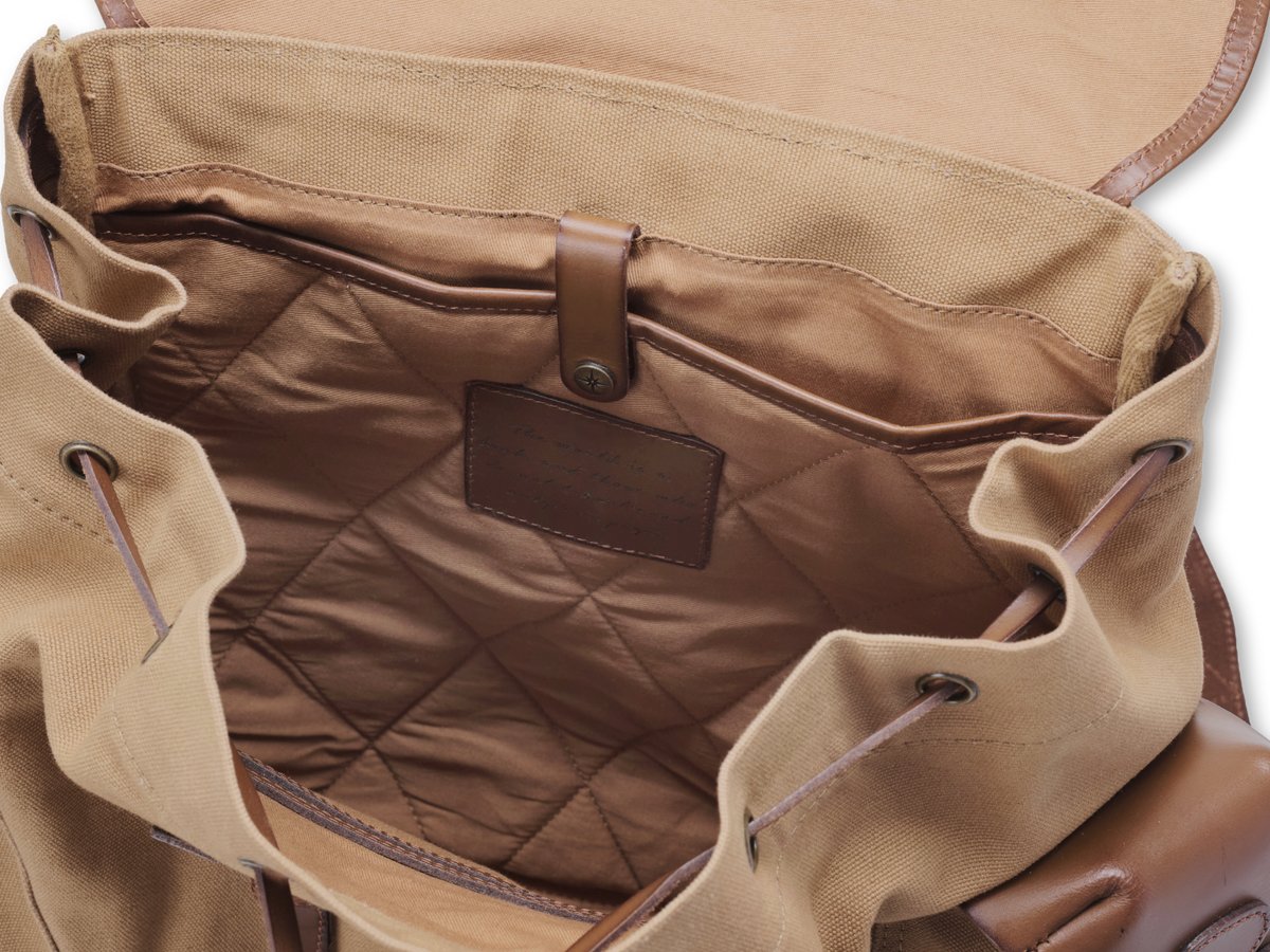 Open Henry backpack with a padded, diamond-quilted laptop compartment and a leather securing strap.