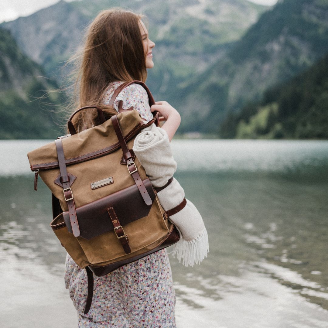 Frau steht am See mit einem Drakensberg Rucksack Adam aus gewachstem Canvas und Leder - hochwertige wasserabweisende Qualität