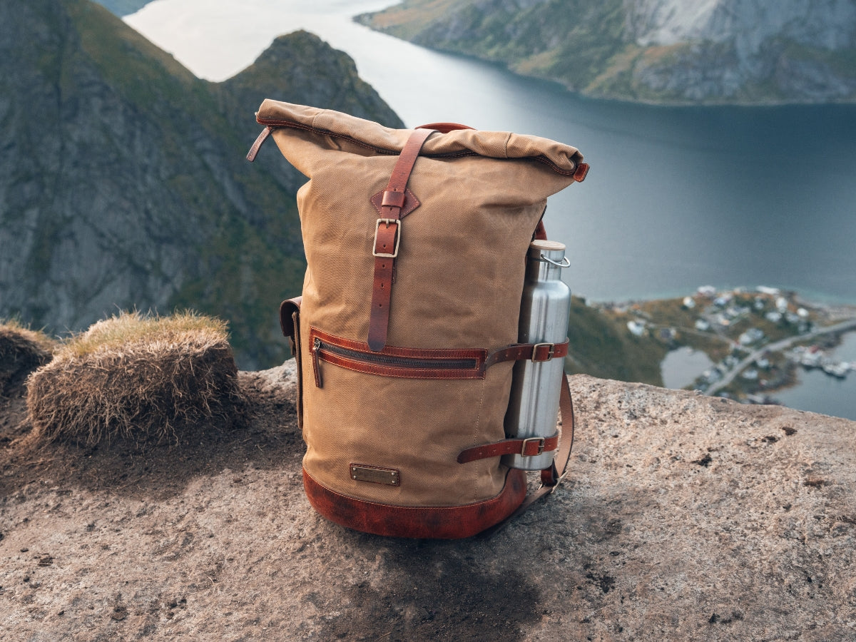 Sac à dos rolltop Dale en toile et cuir sur un rocher au-dessus d'un fjord