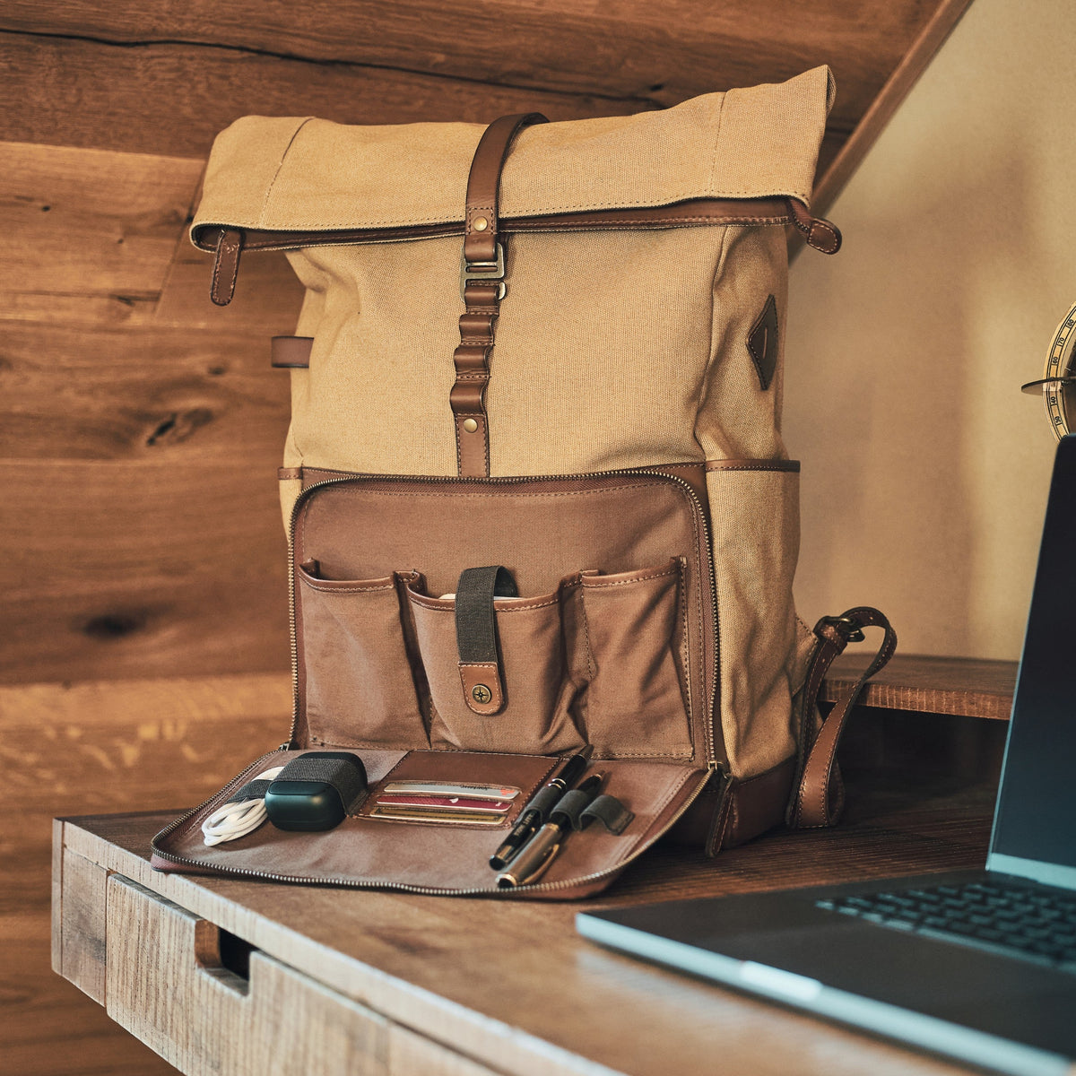 Sac à dos ordinateur Arthur en toile et cuir Beige kaki – organiseur ouvert à côté d’un ordinateur sur un bureau