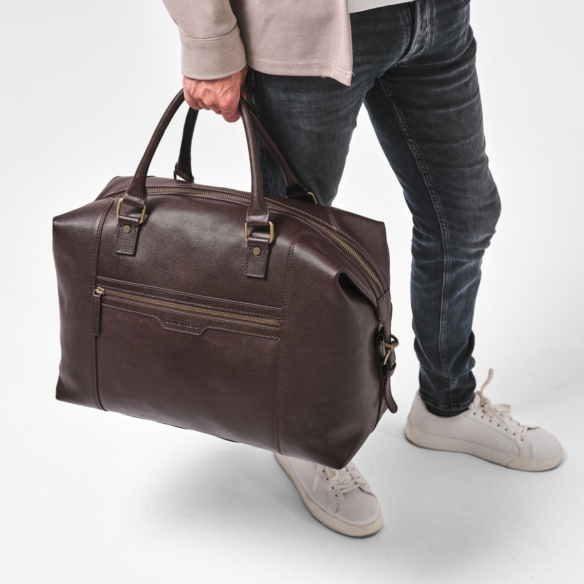 Close-up of a model with the Marcello travel bag in Chocolate Brown
