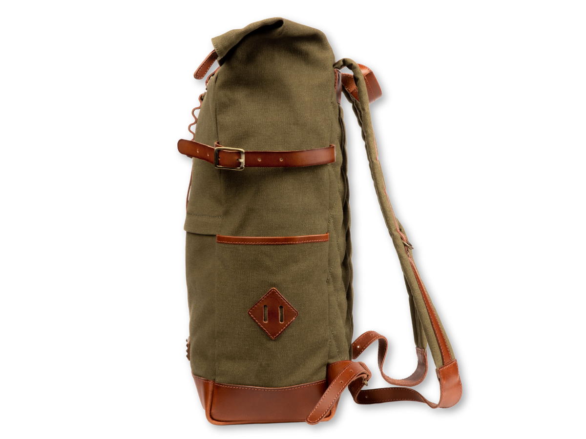 Side bottle pocket of the Wyatt canvas backpack with leather attachment strap and leather base.