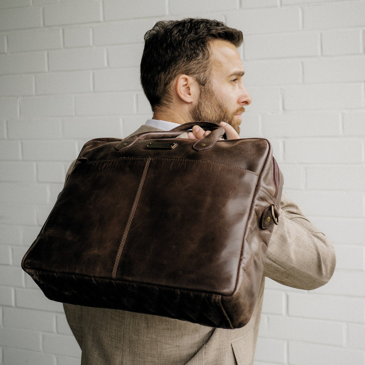 Hugo leather briefcase in Coffee Brown – held over a man’s shoulder