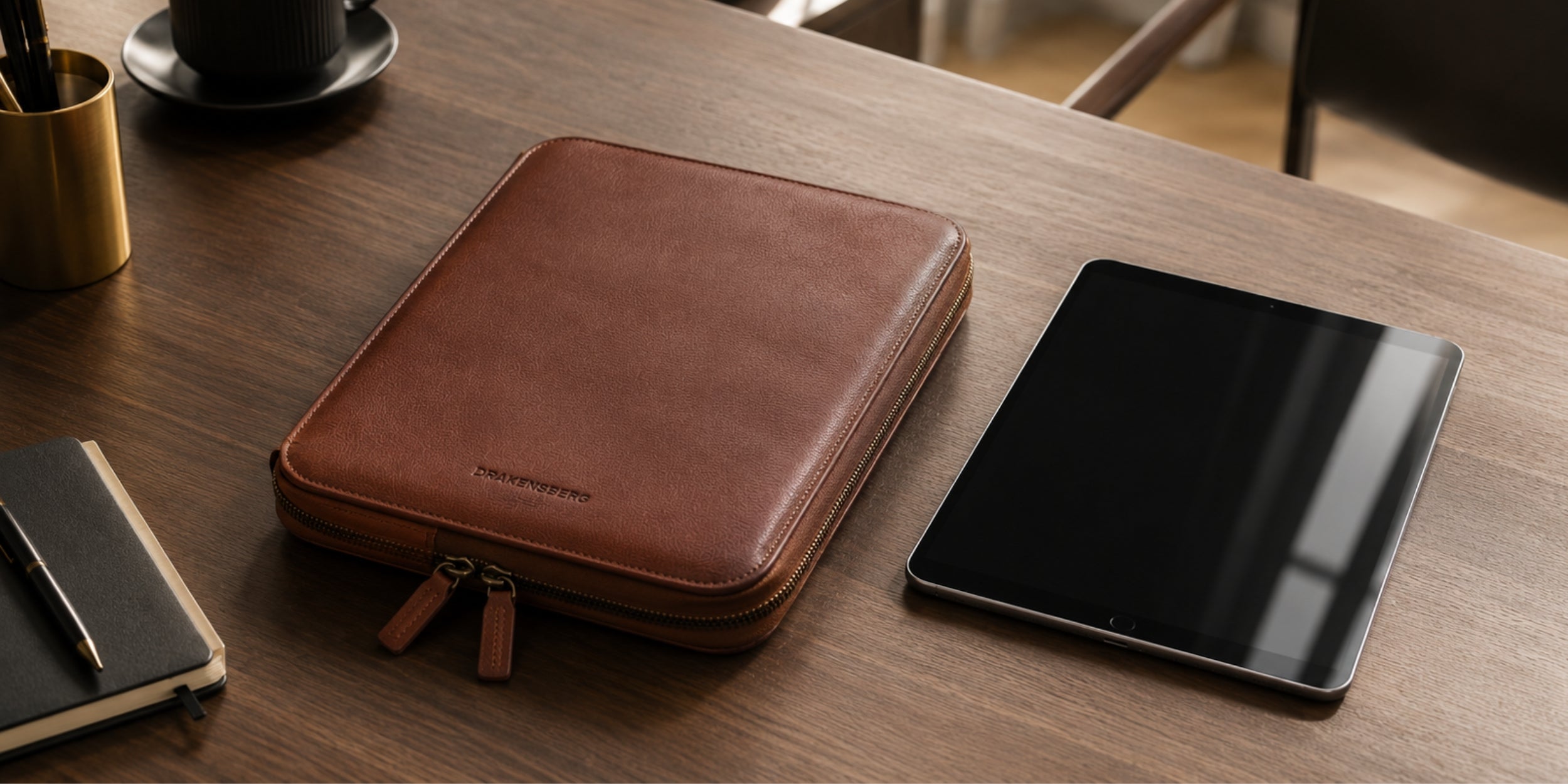 Nolan buffalo leather tablet bag beside a tablet and notebook on a desk