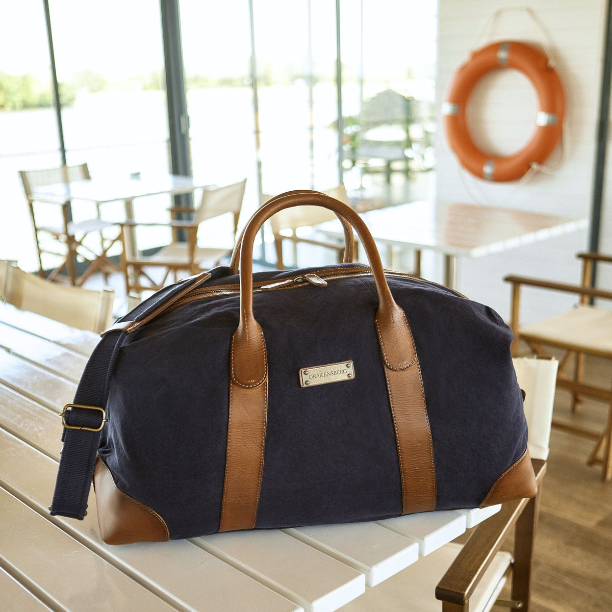 Large David weekender in canvas and leather in Navy Blue – in a harbour restaurant