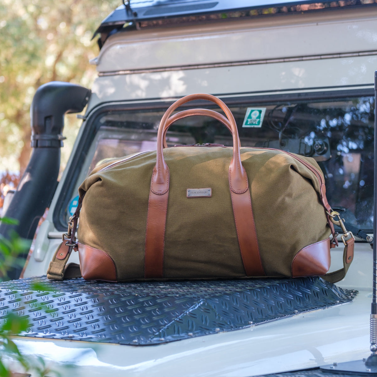 Großer Weekender David aus Canvas und Leder in Oliv-Grün – auf einem Auto