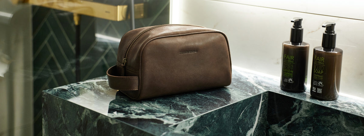 Trousse de toilette en cuir marron sur un plan de toilette en marbre
