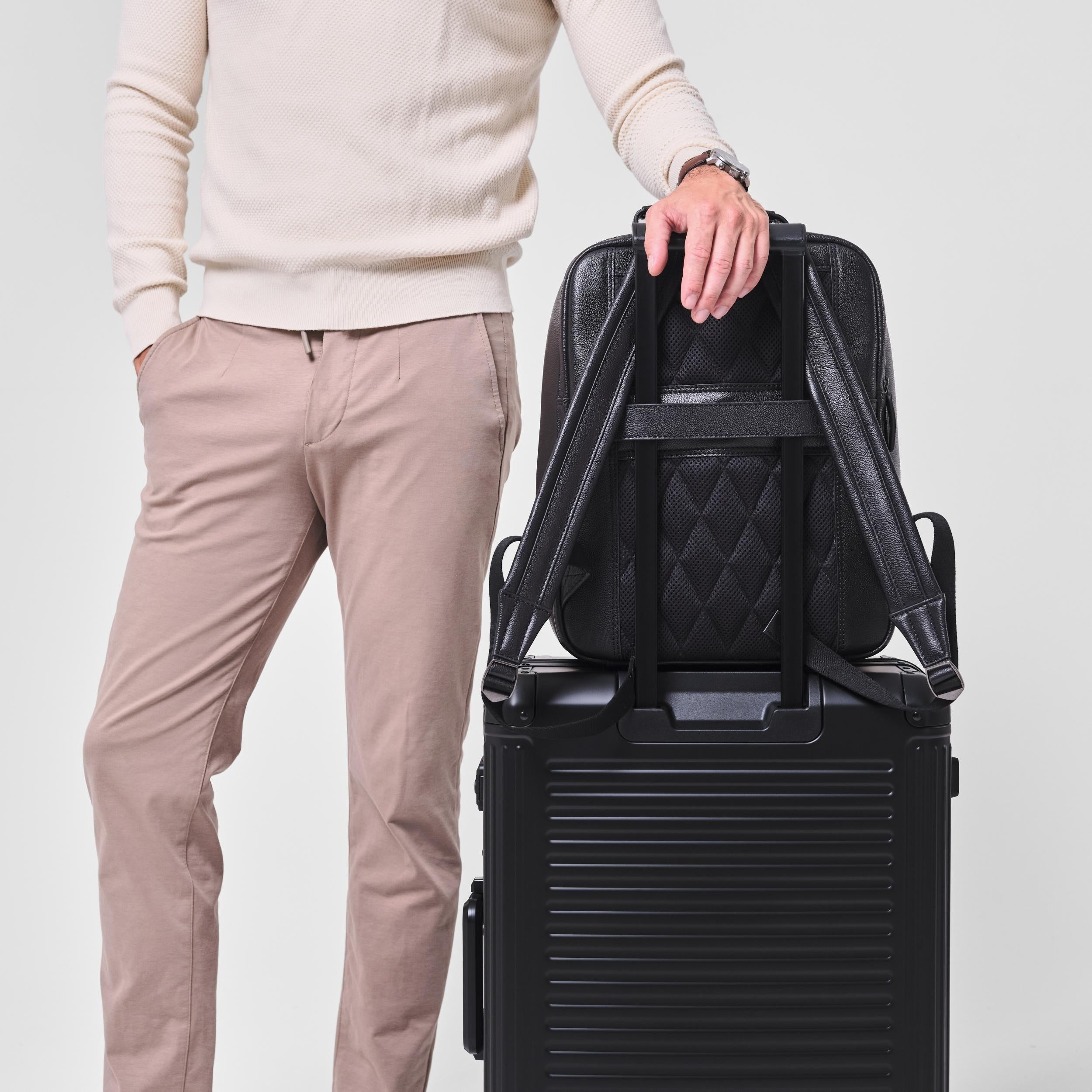 Armando in Schwarz auf einem Rollkoffer mit Trolley-Aufstecklasche