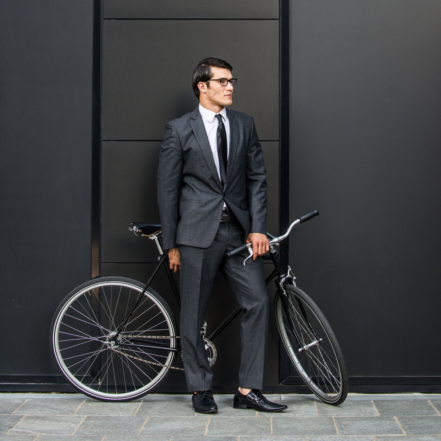 Business Mann steht im Anzug vor seinem eleganten Fahrrad