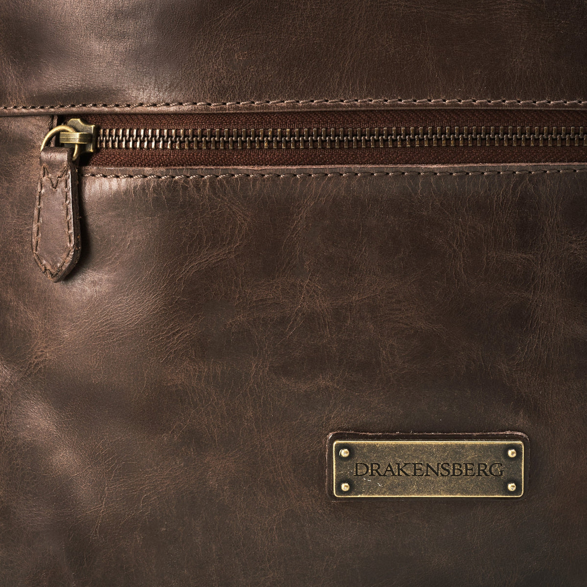 Ryan leather rolltop backpack in Coffee Brown – front zip pocket and DRAKENSBERG logo plate