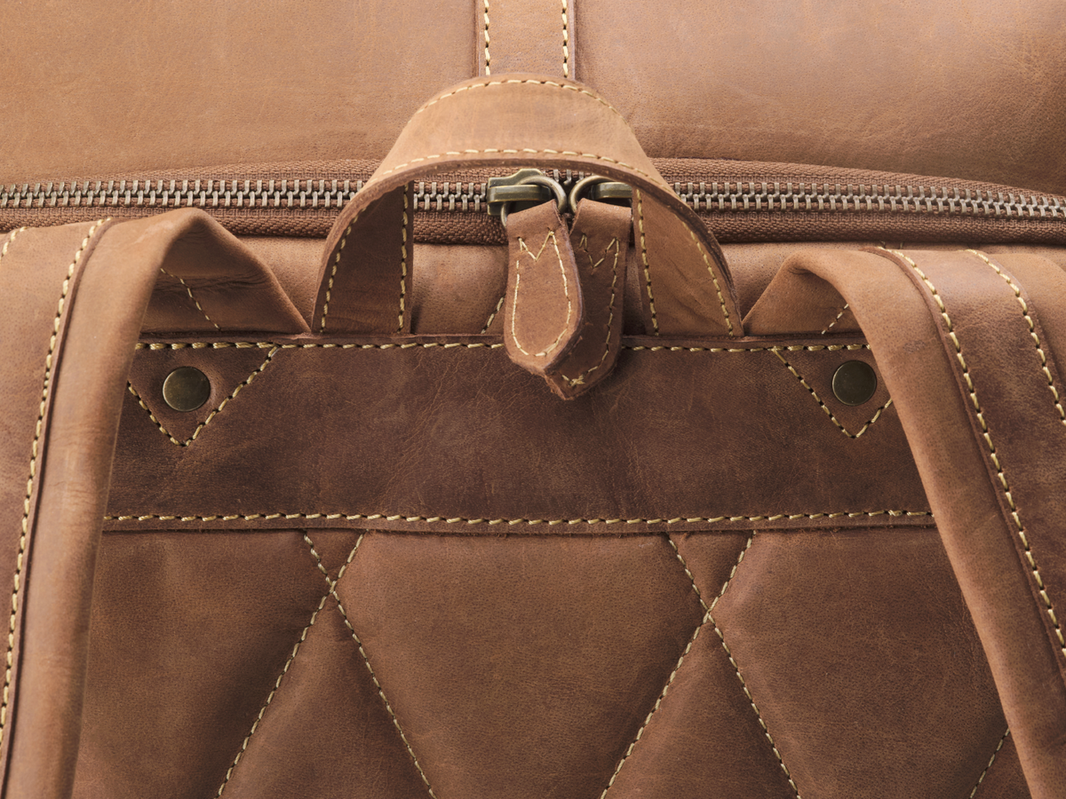 Tragegriff, Metallreißverschluss und gesteppte Rückseite des Lederrucksacks Arthur im Detail