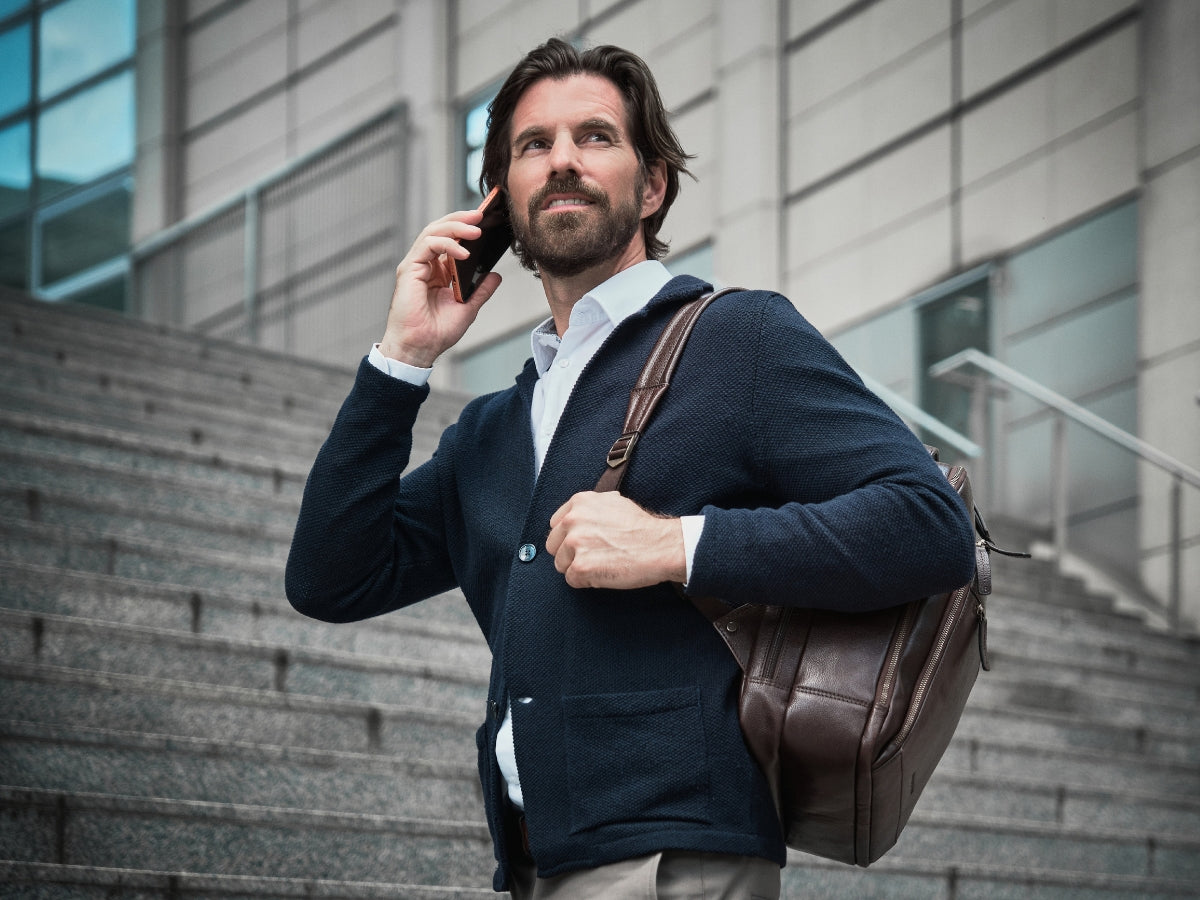 Homme en costume portant un sac à dos business marron sur l’épaule