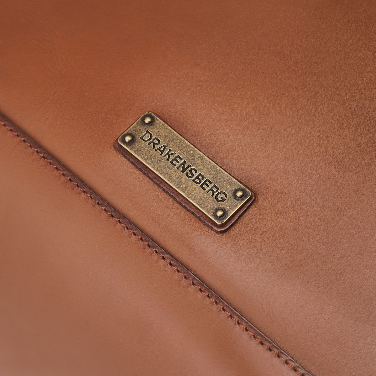 Sac à dos ordinateur Arthur en toile et cuir Beige kaki – détail de la plaque DRAKENSBERG et des coutures du cuir