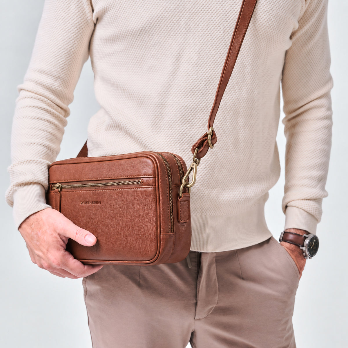Pochette Roberto Marron châtaigne portée avec la dragonne