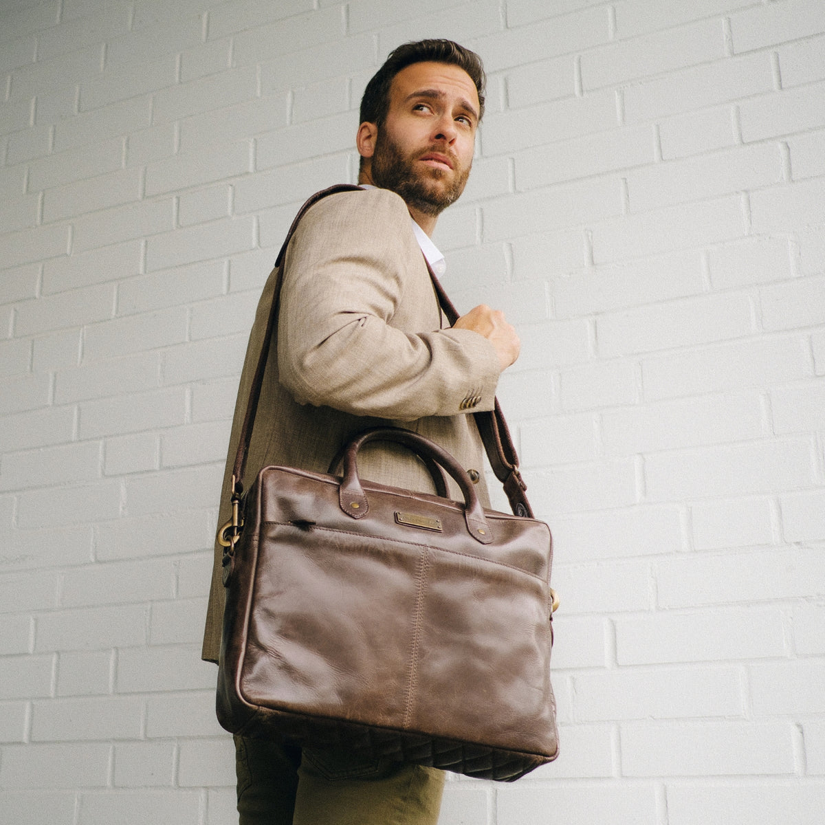 Mann trägt die braune Leder-Aktentasche Hugo als Schultertasche