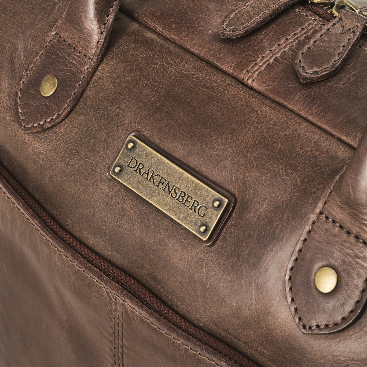 Hugo leather briefcase in Coffee Brown – detail of leather, stitching and brand plate
